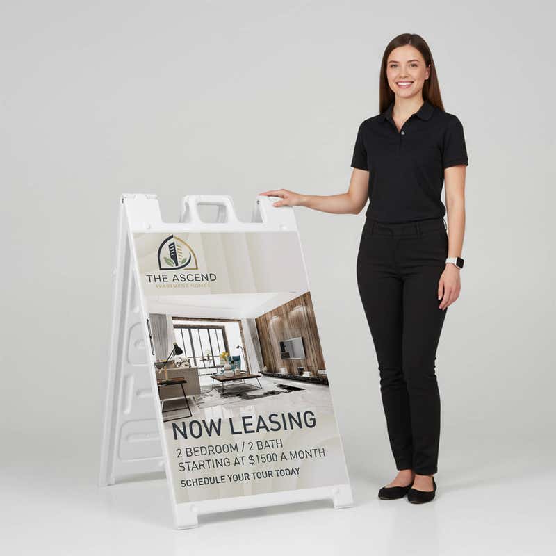 Woman standing beside a now leasing A-frame sign for scale