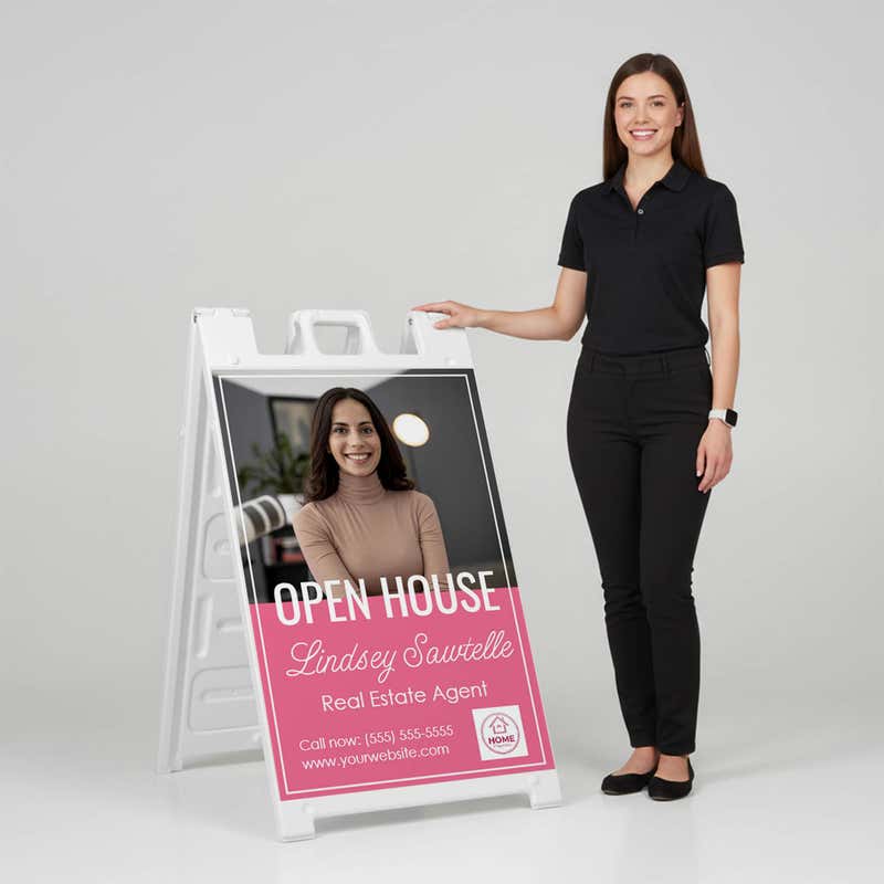 Woman standing beside a pink open house A-frame sign for scale