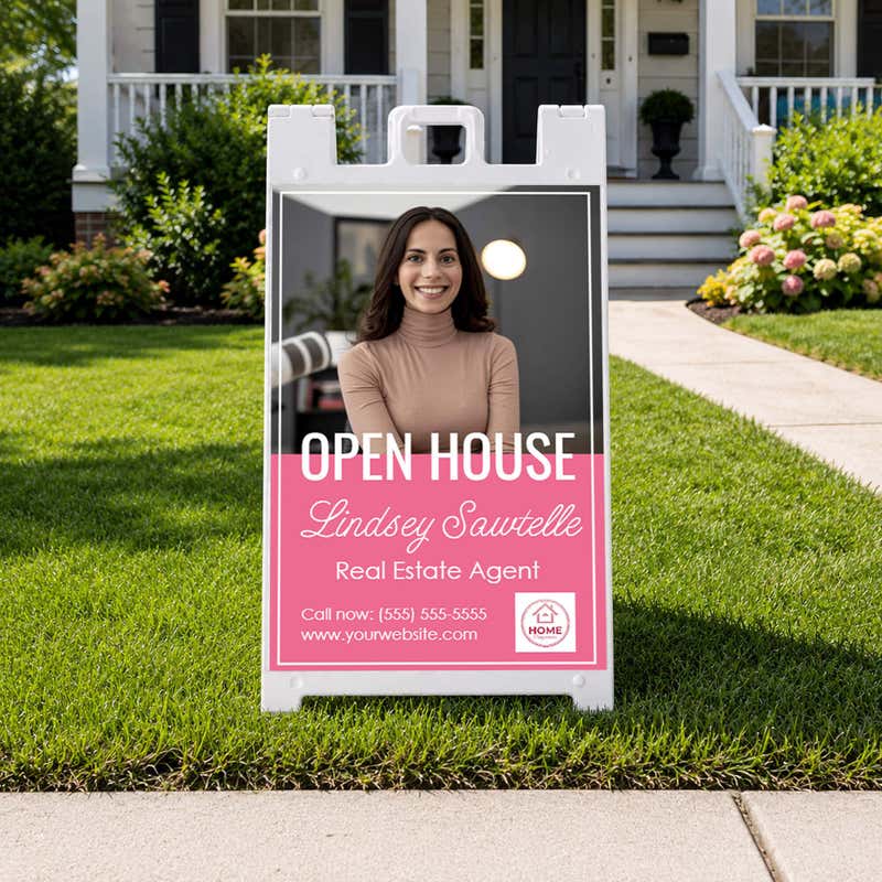 Pink open house real estate A-frame sign in a home front yard