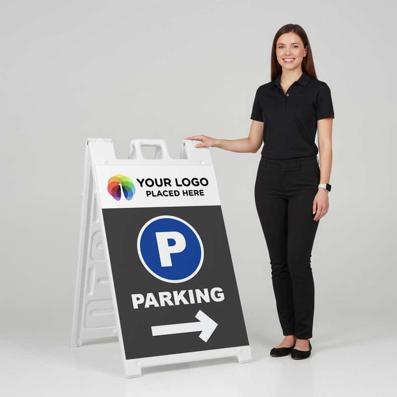 Woman standing beside a logo parking A-frame sign for scale