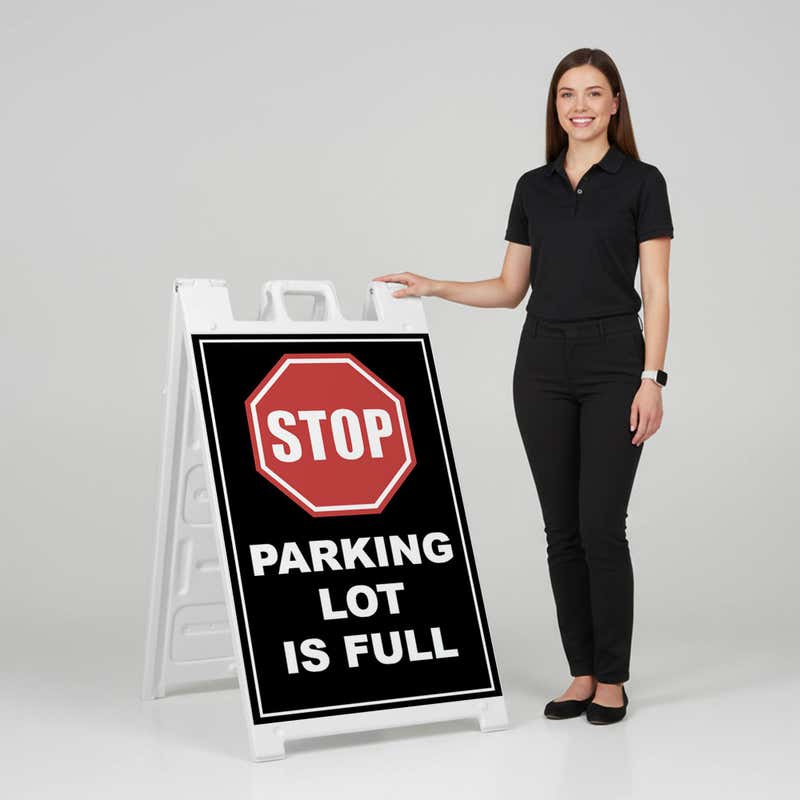 Woman standing beside a parking lot full A-frame sign for scale