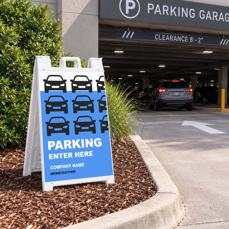 Parking Enter Here A-frame sign placed in a landscaped lot entrance
