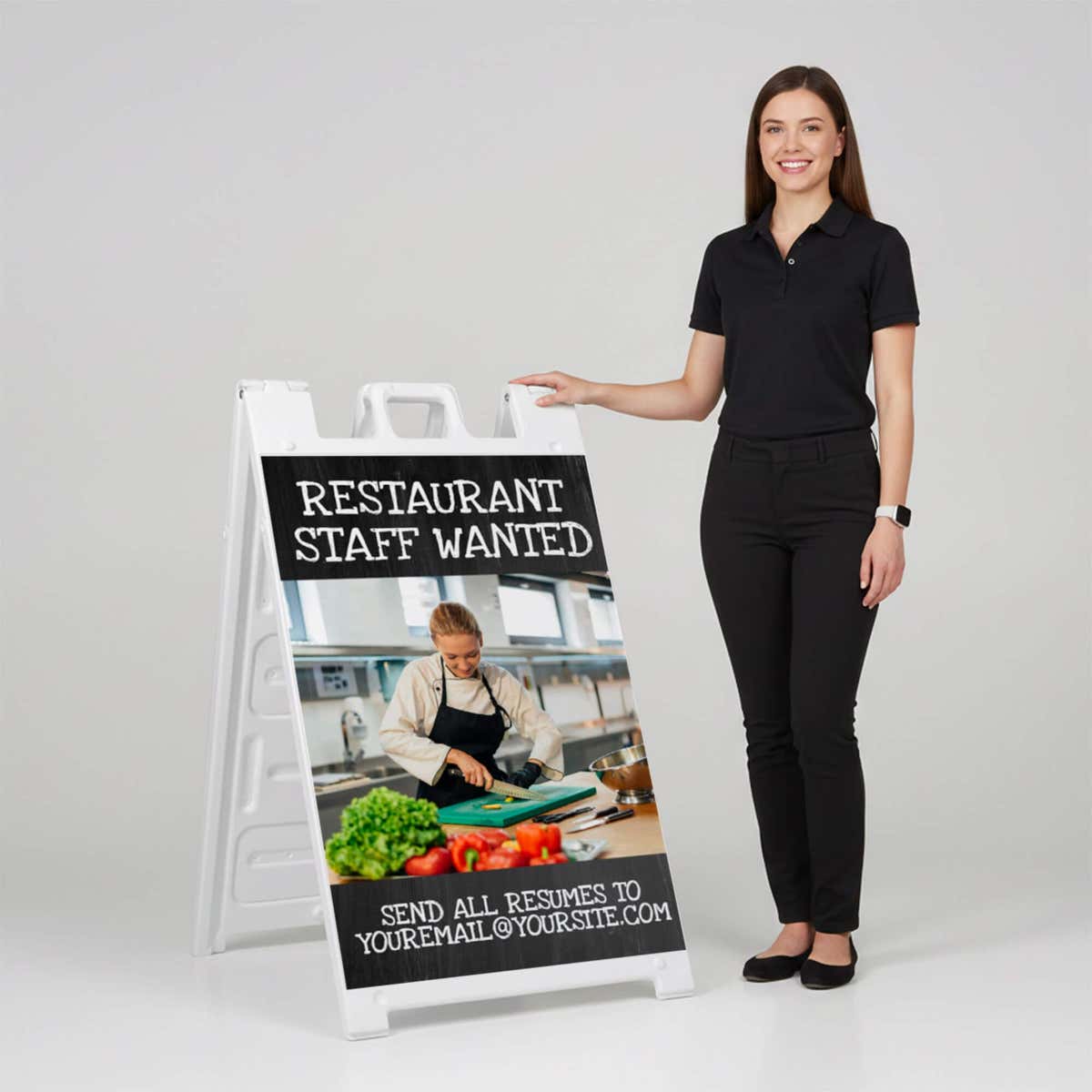 Woman standing beside a restaurant staff wanted A-frame sign for scale