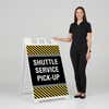 Woman standing beside a shuttle service A-frame sign for scale