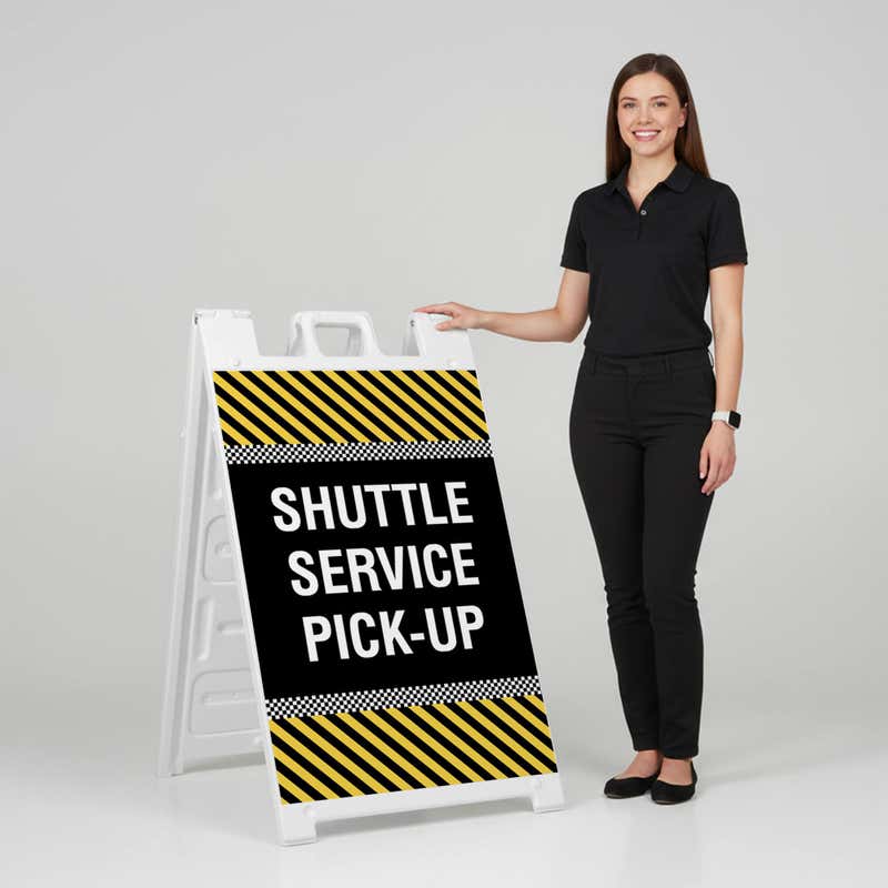 Woman standing beside a shuttle service A-frame sign for scale