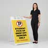 Woman standing beside a student pickup A-frame sign for scale