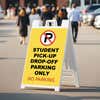Student pickup A-frame sign displayed in a parking lot