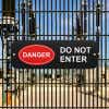 Black sign that reads “Do Not Enter” in white and red oval Danger Icon in white text