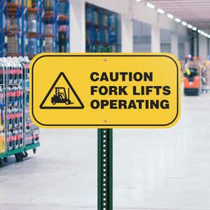 Yellow background custom sign with bold black text that reads: Caution Forklifts Operating with forklift icon