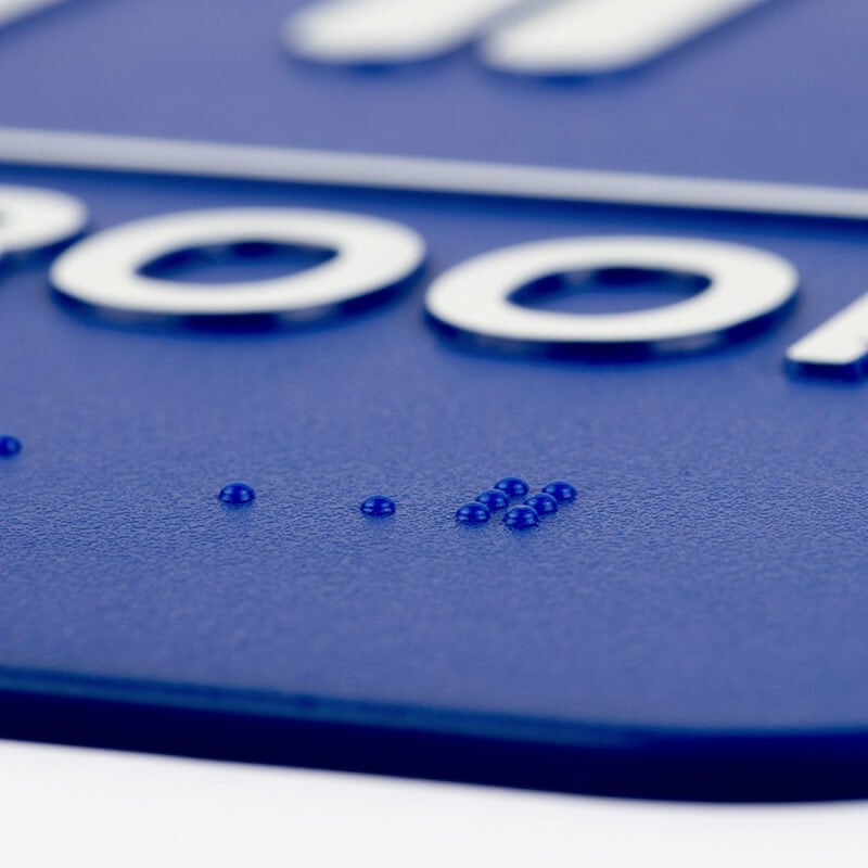 A close-up on the braille for the 9 x 6 ADA sign