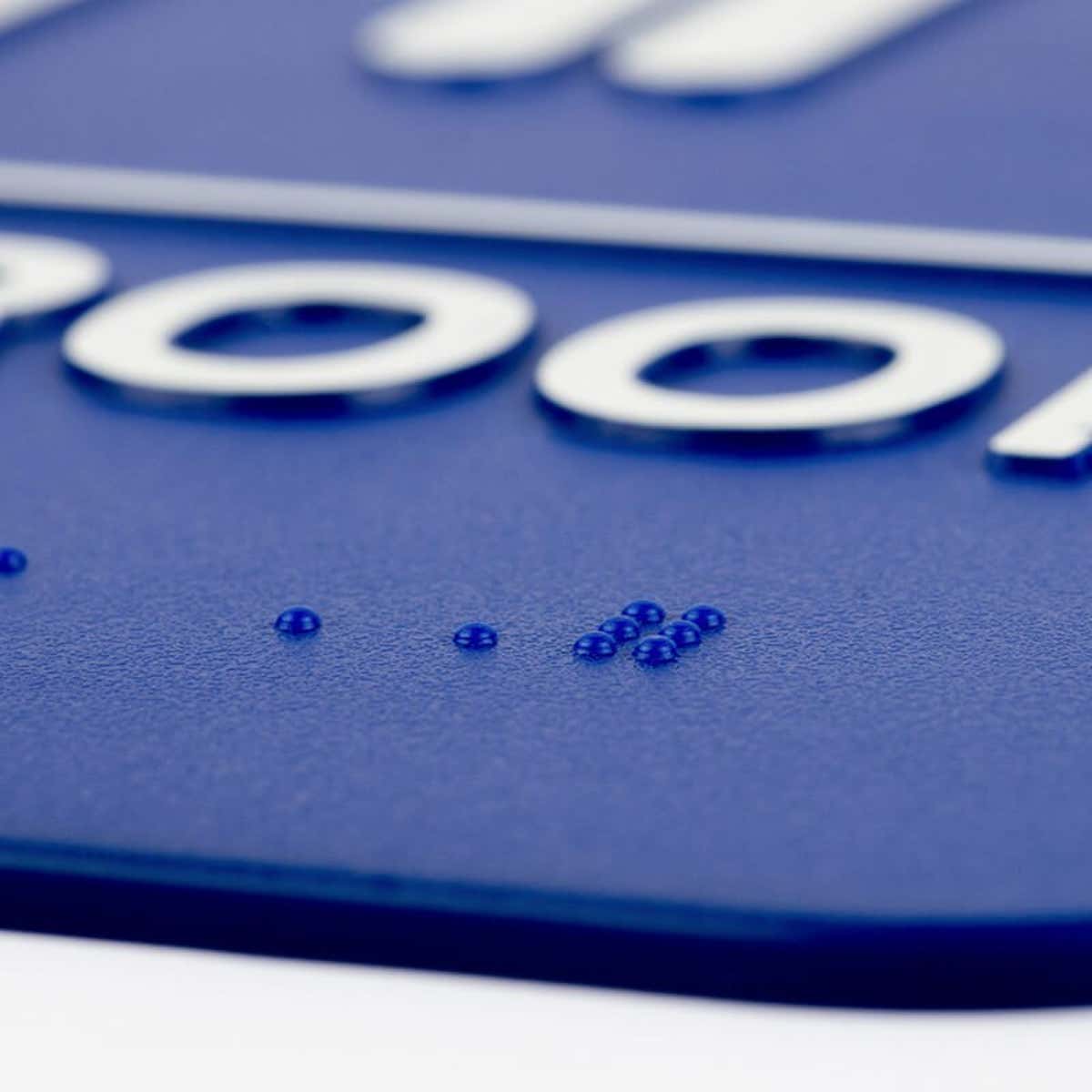 A close-up on the braille for the 9 x 6 ADA sign