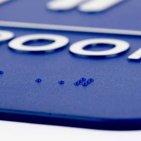 A close-up on the braille for the 9 x 6 ADA sign