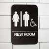 Brown Unisex Handicap Sign Hanging on a Wall