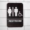 Brown Unisex Handicap Sign Hanging on a Wall