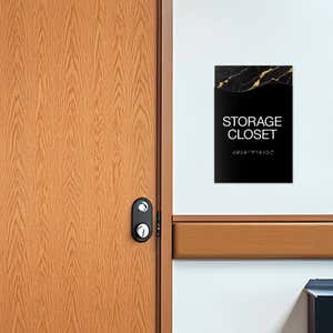 A 2-layer modern flow ADA sign for a storage closet with a black foreground and a black marble background