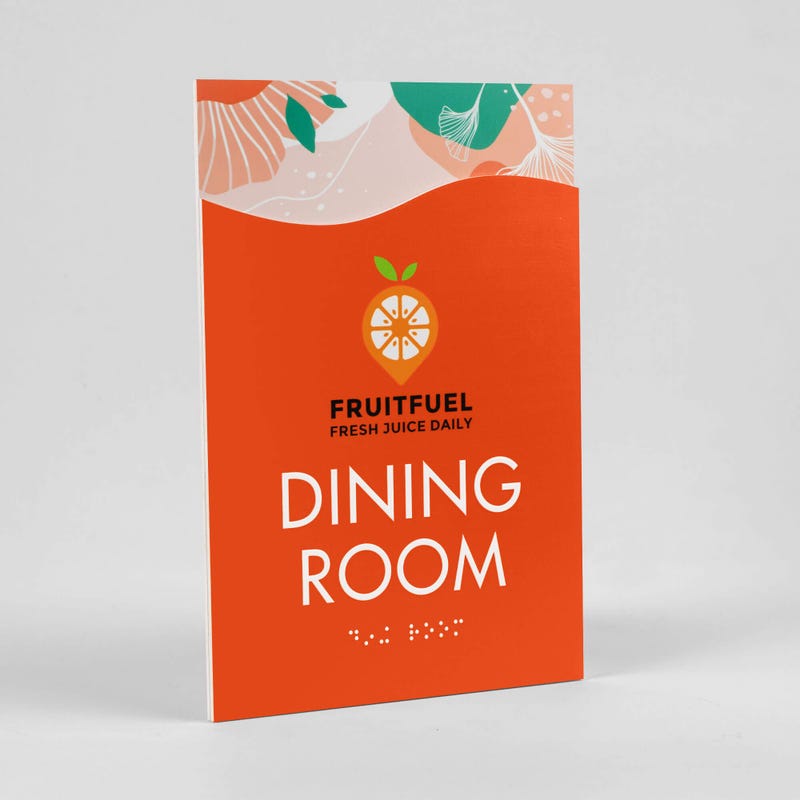A 2-layer ADA sign for a dining room with an orange foreground and orange floral background sitting at an angle