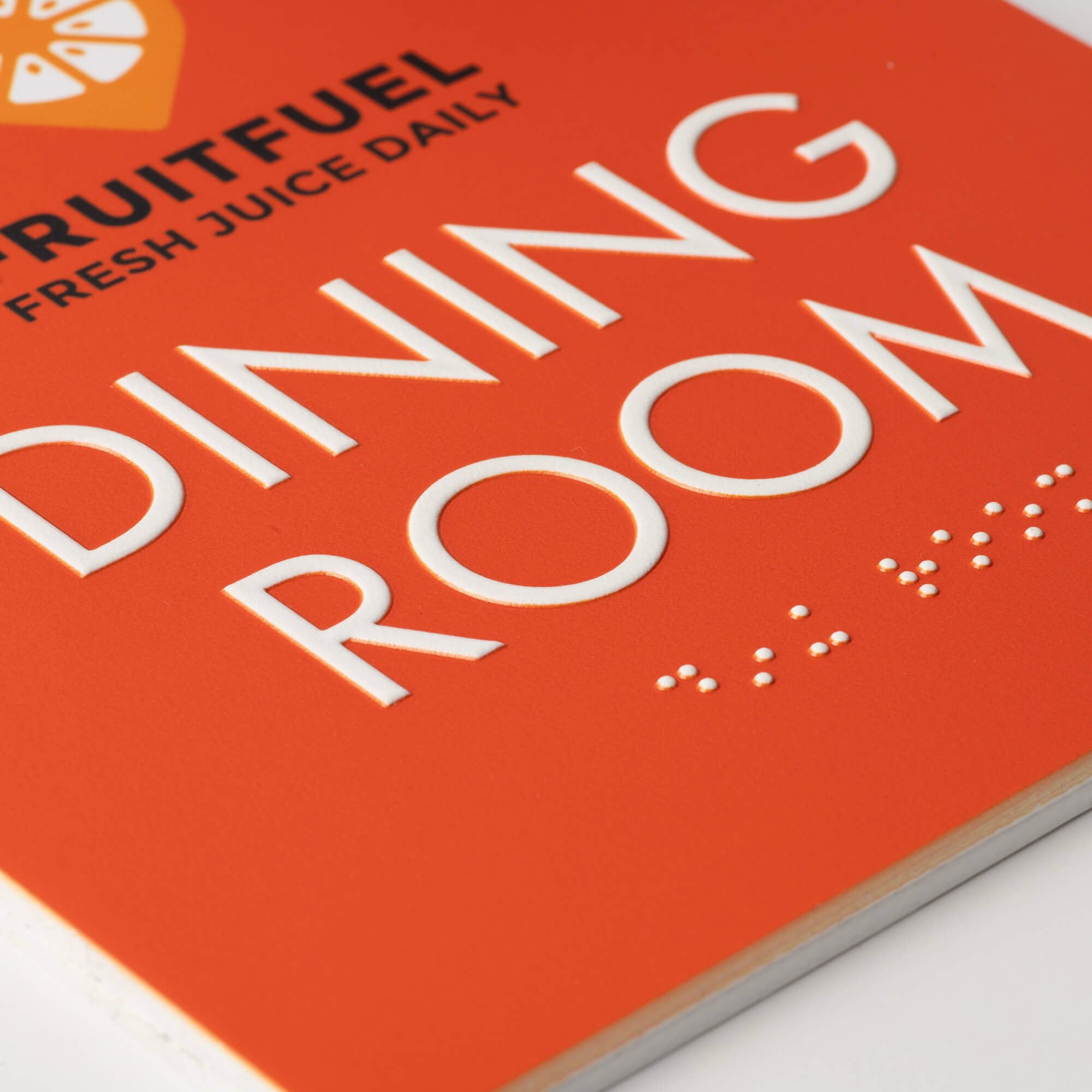 A close-up on the braille and tactile text on the ADA sign A close-up on the braille and tactile text on the ADA sign