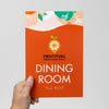 A person holding an orange 2-layer modern ADA sign for a dining room