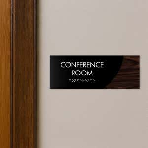A 2-layer ADA sign for a conference room with a black foreground and a dark woodgrain background