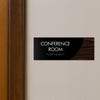 A 2-layer ADA sign for a conference room with a black foreground and a dark woodgrain background