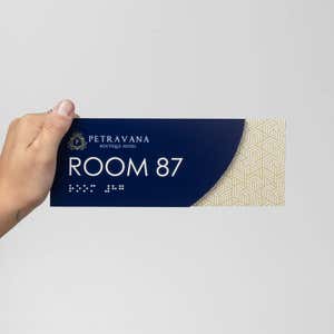 A person holding the modern sleek 2-layered ADA sign