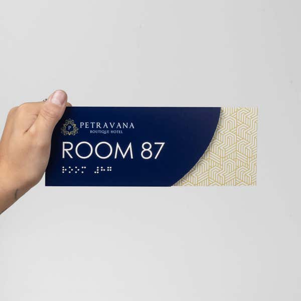 A person holding the modern sleek 2-layered ADA sign