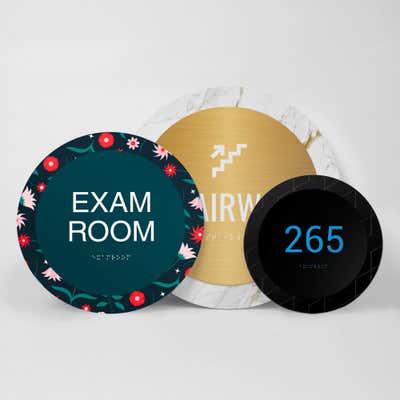 Three different sizes and designs of the round 2-layered ADA sign
