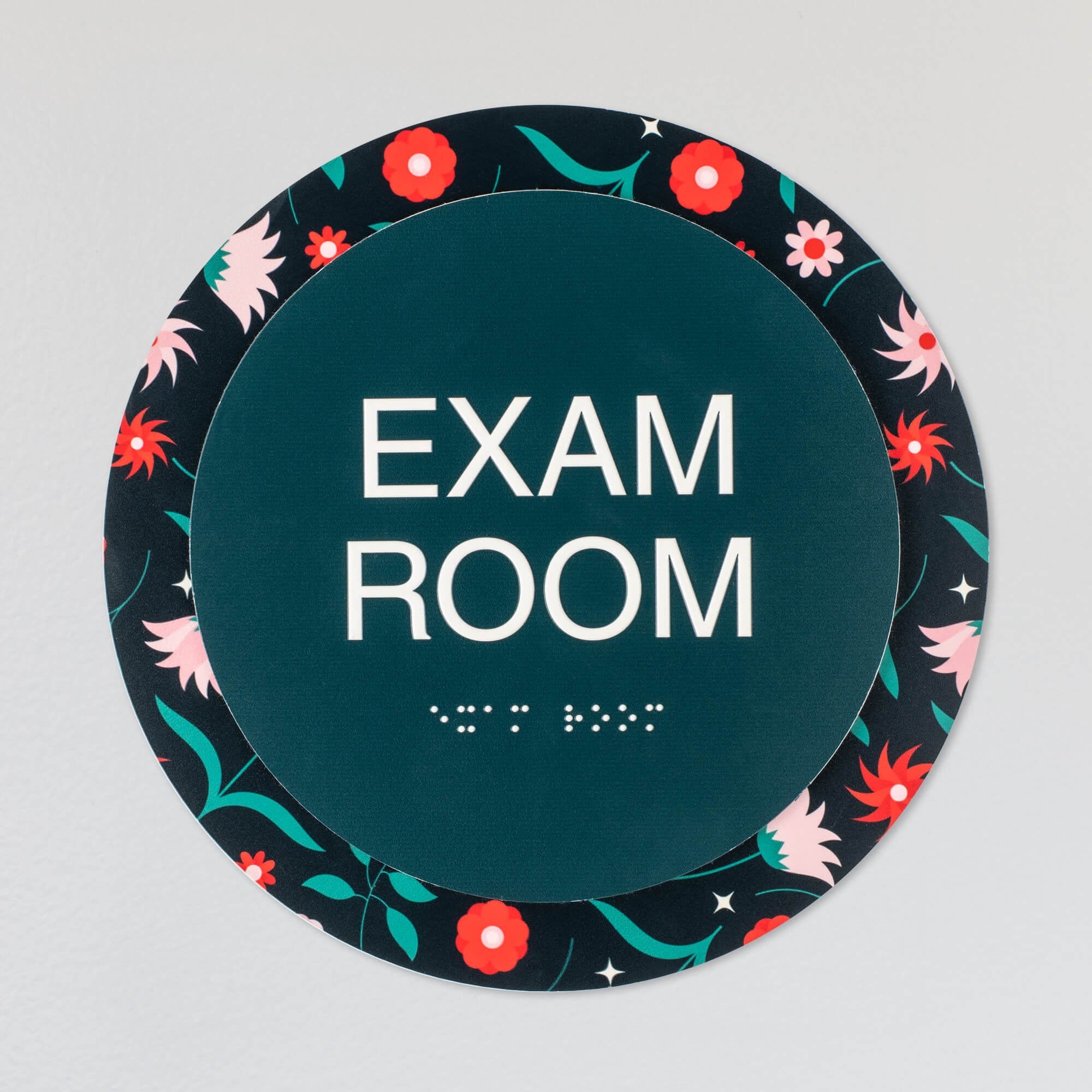 The custom round 2-layered ADA sign hanging on a wall for an exam room The custom round 2-layered ADA sign hanging on a wall for an exam room
