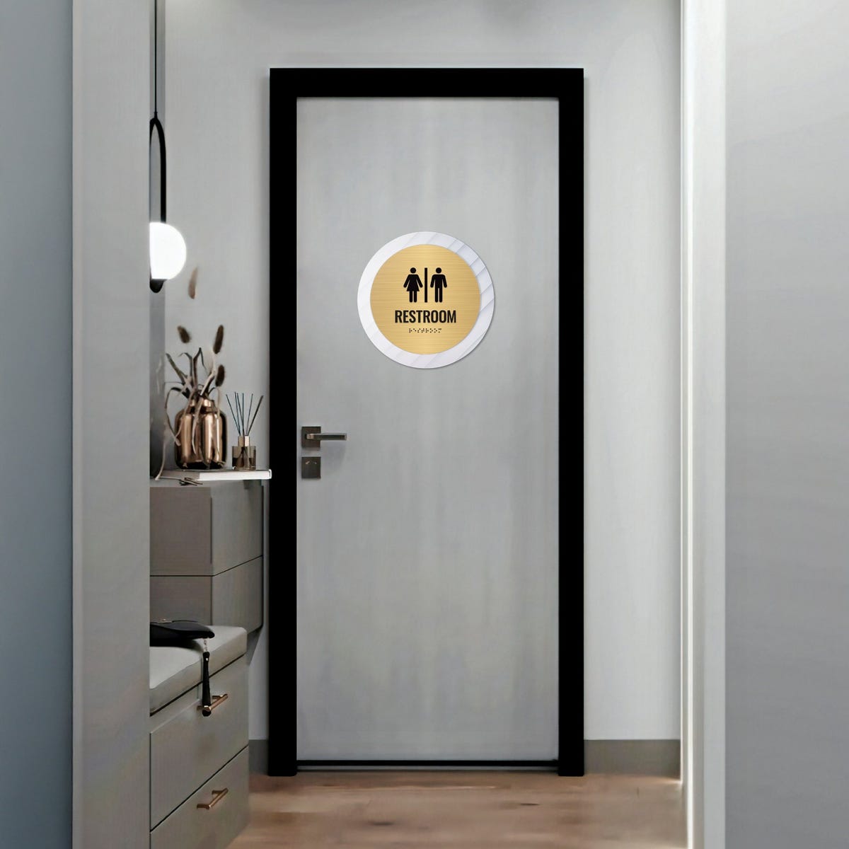A large 2-layer round ADA sign for a restroom on the outside of a door