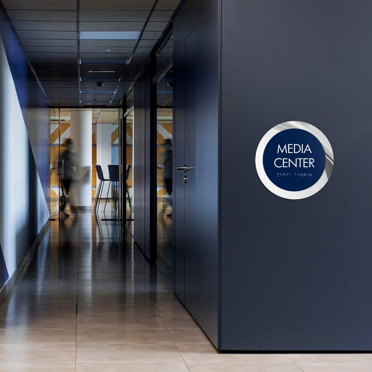 A large 2-layer round ADA sign for a media center on a wall