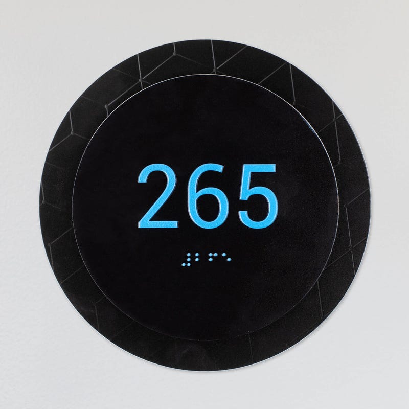 An example of a small round 2-layer ADA sign for a room number
