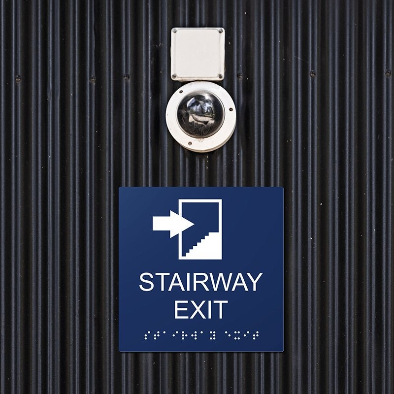 A blue ADA sign for a stairway exit with an arrow pointing right