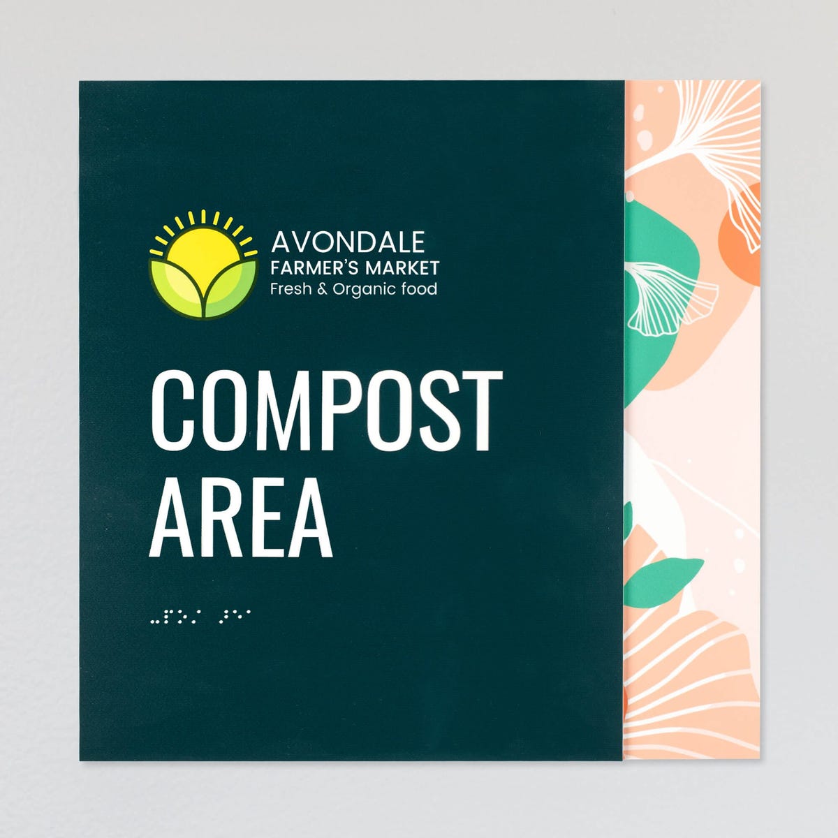 An example of a layered ADA sign design for a compost area with a green foreground and an orange floral background