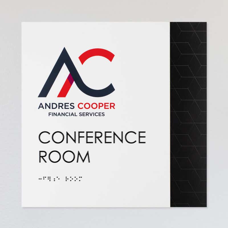 An example of a layered ADA sign design for a conference room with a white foreground and black geometric background