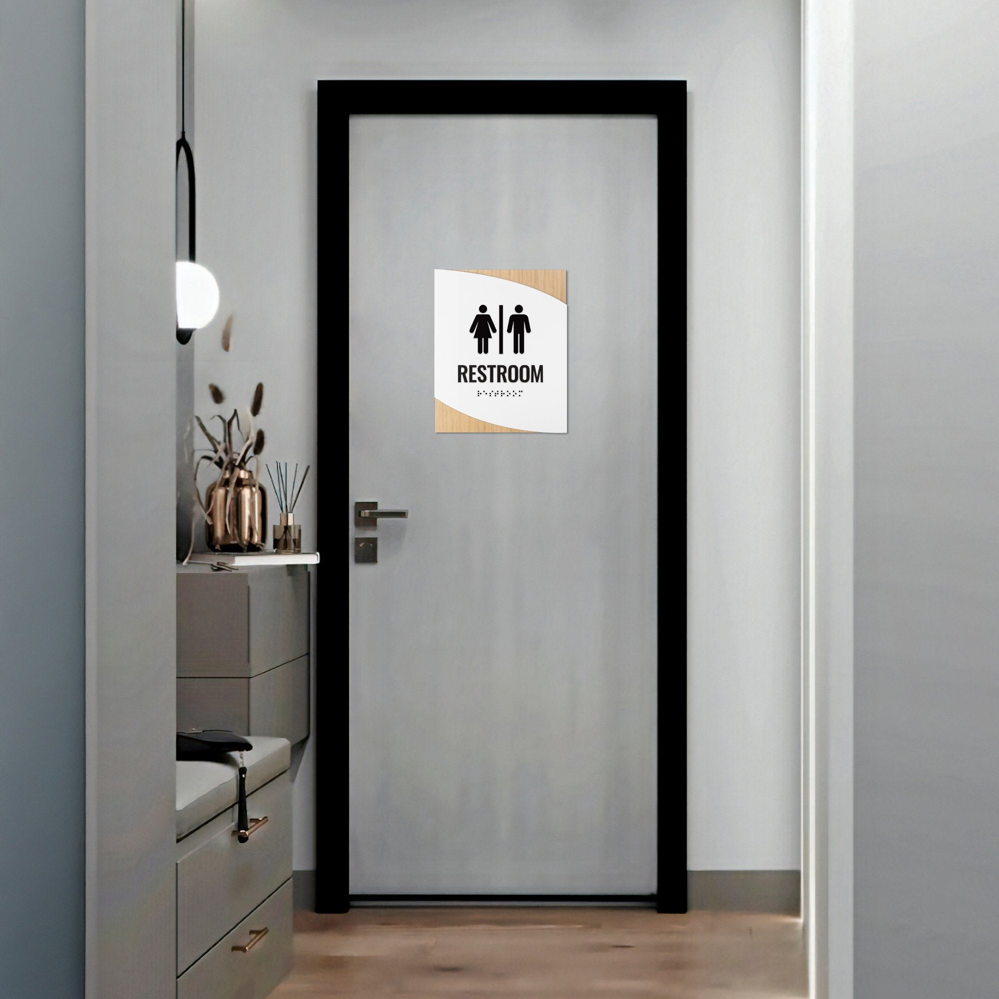 A modern twist design ADA sign for a restroom with a light wood background and white foreground
