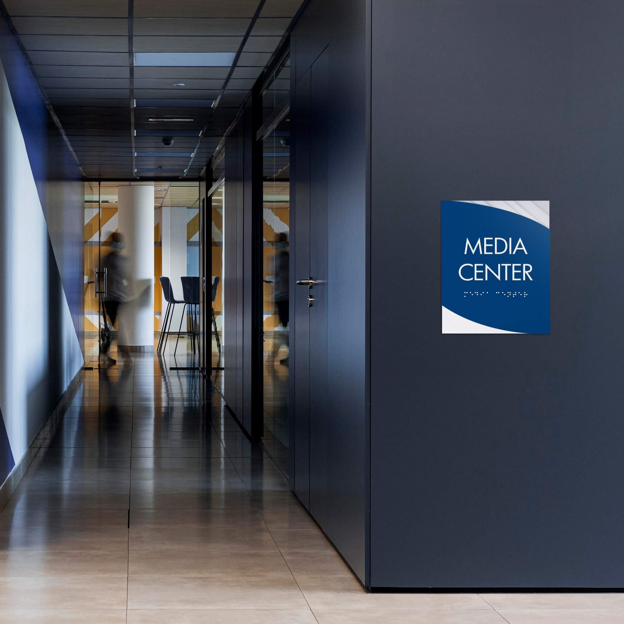 A modern twist design ADA sign for a media center with the basic swoop background and royal blue foreground