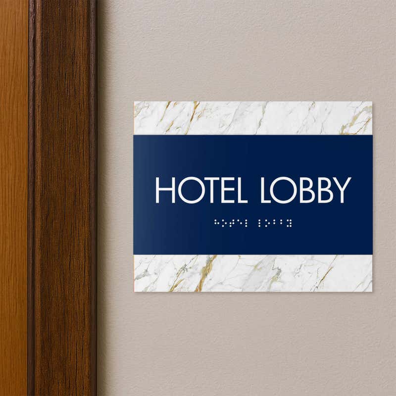A 2-layered horizontal ADA sign for a hotel lobby with a blue foreground and white marble background