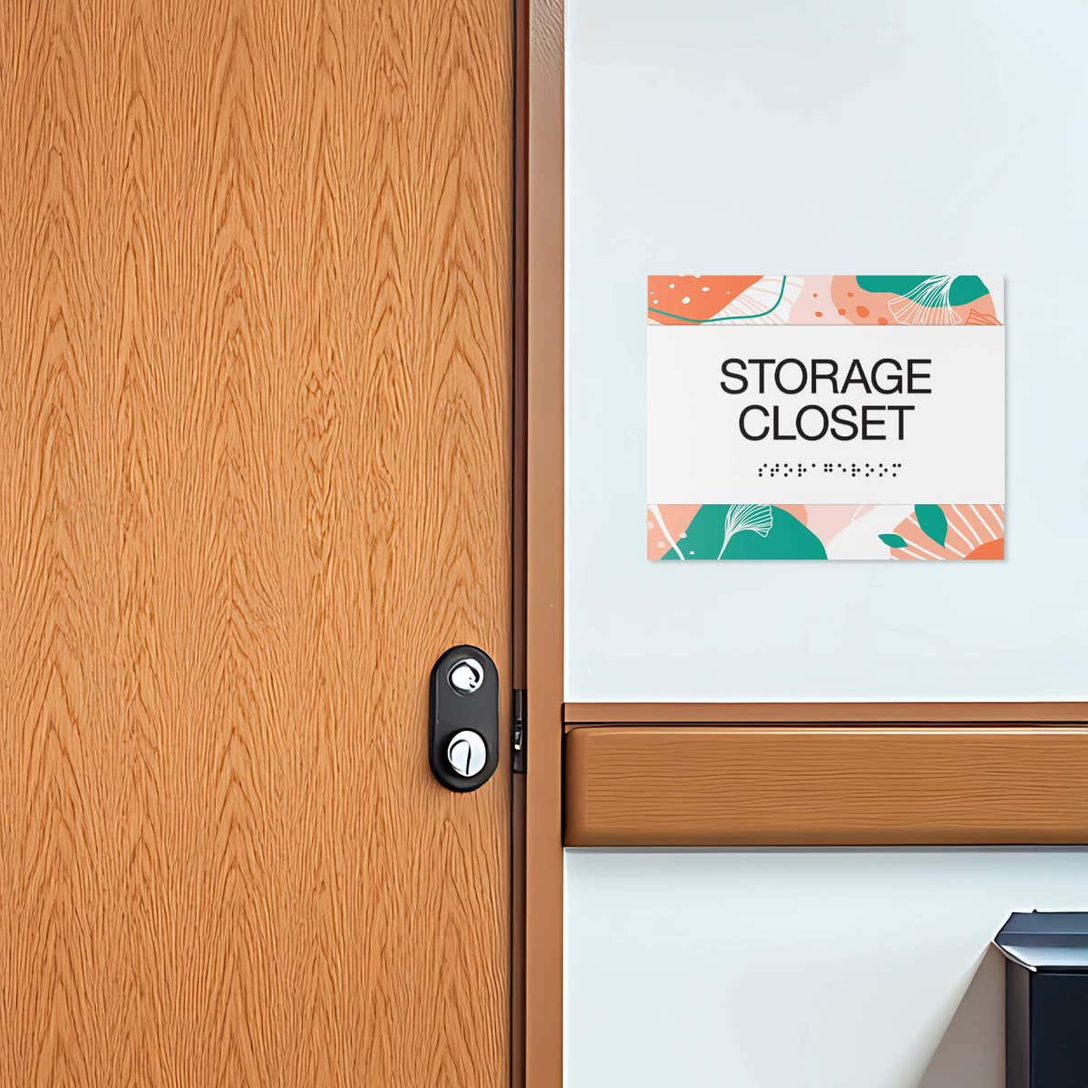 The horizontal 2-layer ADA sign for a storage closet with a white foreground and orange floral background