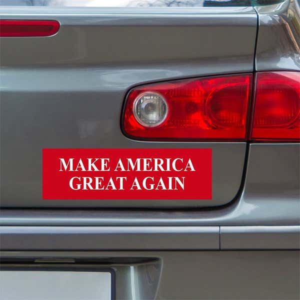 Make American Great Again Bumper Sticker below a gray car's tail light