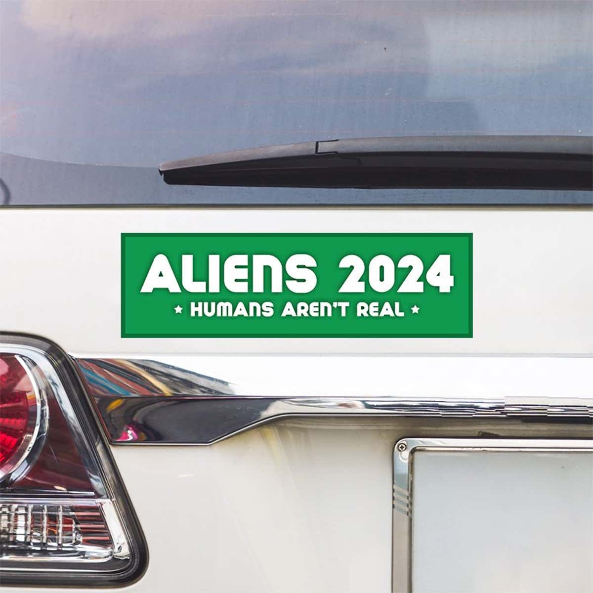 Aliens - Humans Aren't Real Bumper Sticker above a white car's tail light