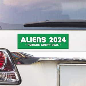 Aliens - Humans Aren't Real Bumper Sticker above a white car's tail light