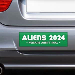 Aliens - Humans Aren't Real Bumper Sticker on the bumper of a gray car