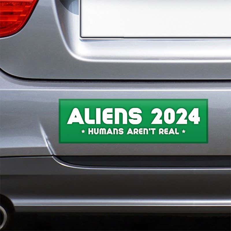 Aliens - Humans Aren't Real Bumper Sticker on the bumper of a gray car