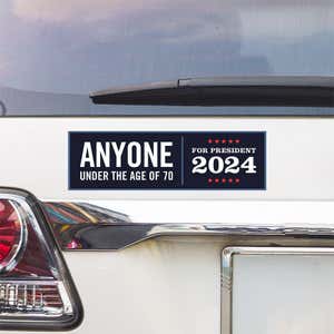 Anyone Under 70 bumper sticker above a white car's tail light