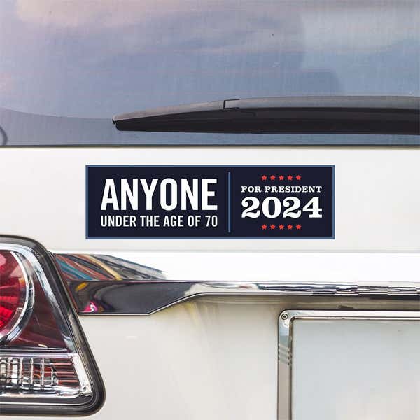 Anyone Under 70 bumper sticker above a white car's tail light