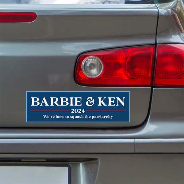 Barbie and Ken bumper sticker below a gray car's tail light