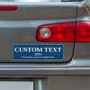 Custom Text Political Bumper Sticker below a gray car's tail light