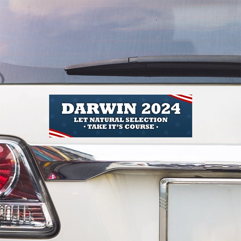 Darwin Political Bumper Sticker above a white car's tail light
