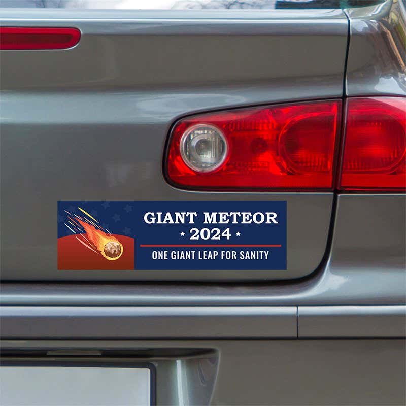 Giant Meteor Bumper Sticker below a gray car's tail light