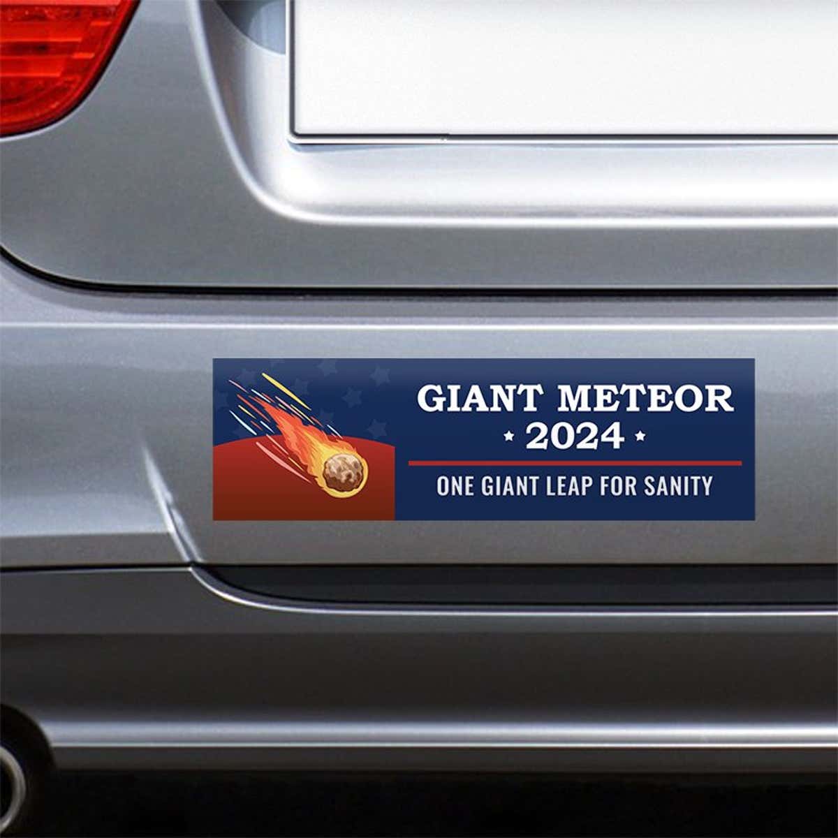 Giant Meteor Bumper Sticker on the bumper of a gray car